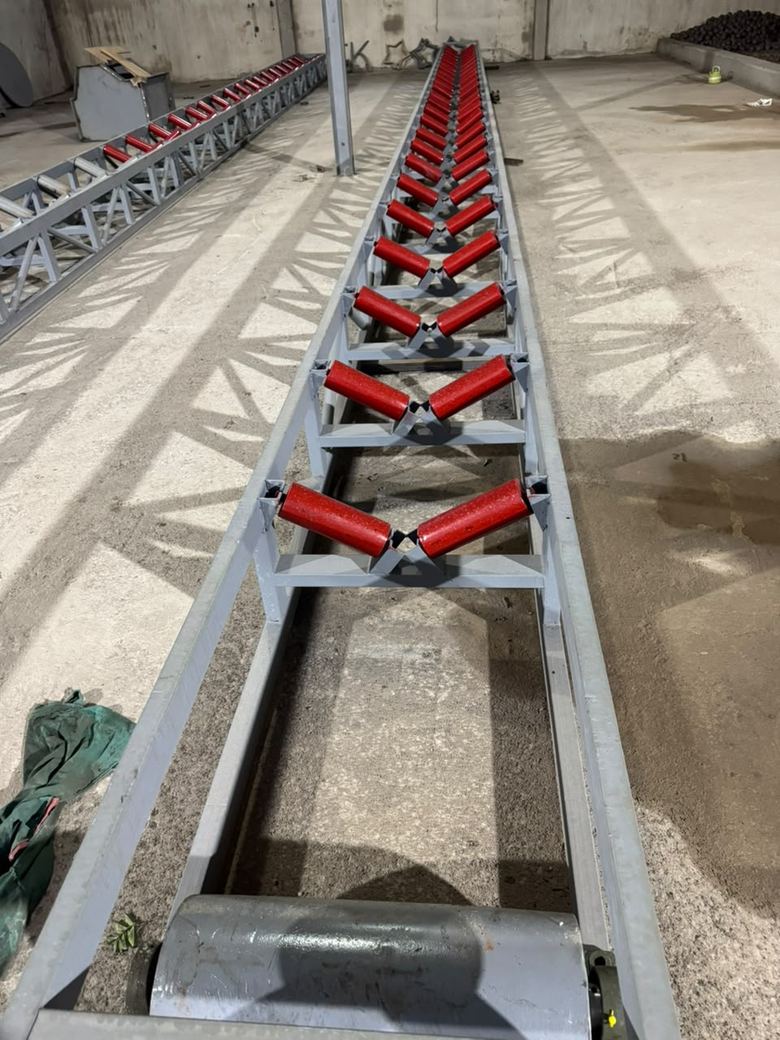 Long châssis de convoyeur aux rouleaux rouges, en atelier